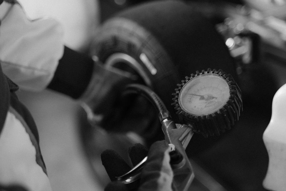 Technician checking wheel alignment and tire pressure
